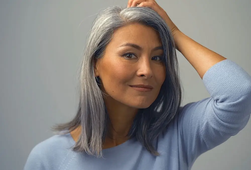 middle aged woman putting her fingers through her hair