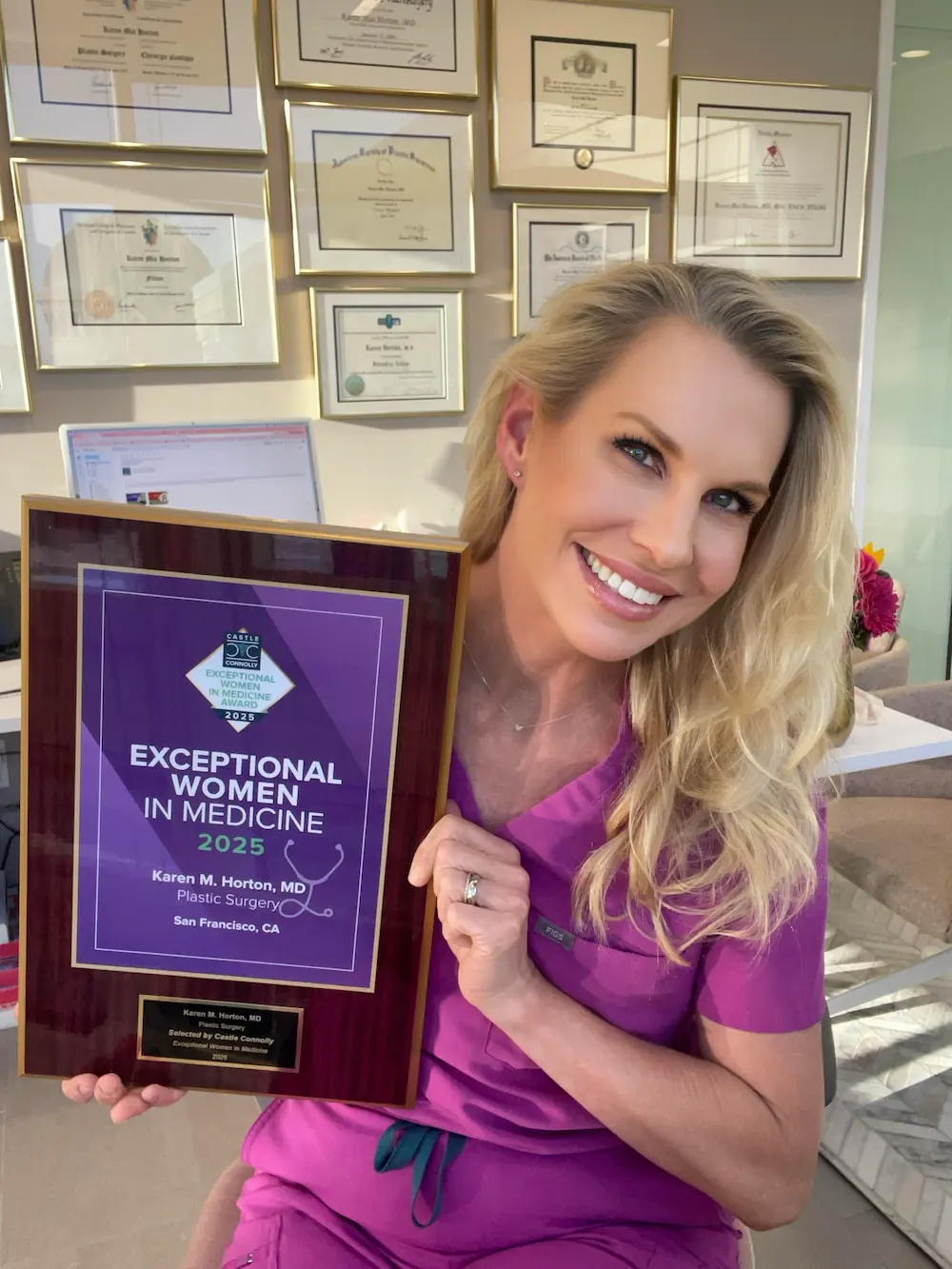 Dr. Karen Horton holding Exceptional Women in Medicine award