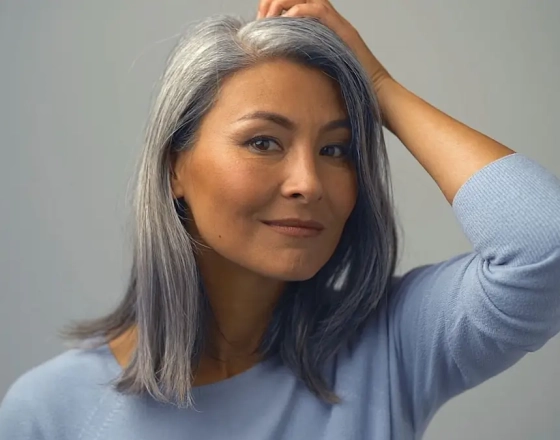 middle aged woman putting her fingers through her hair