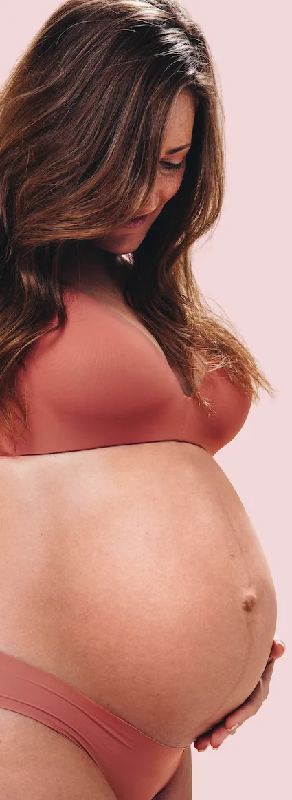 beautiful pregnant woman showing off her growing body