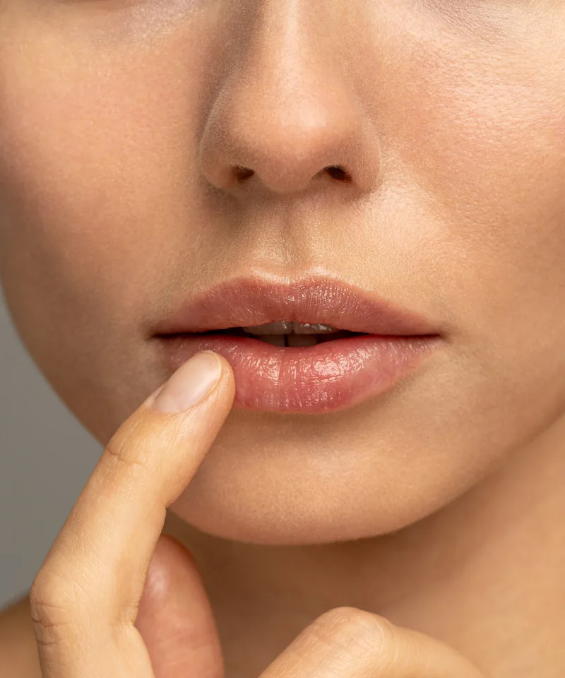 woman touching youthful natural-looking lips after Swedish lip filler technique